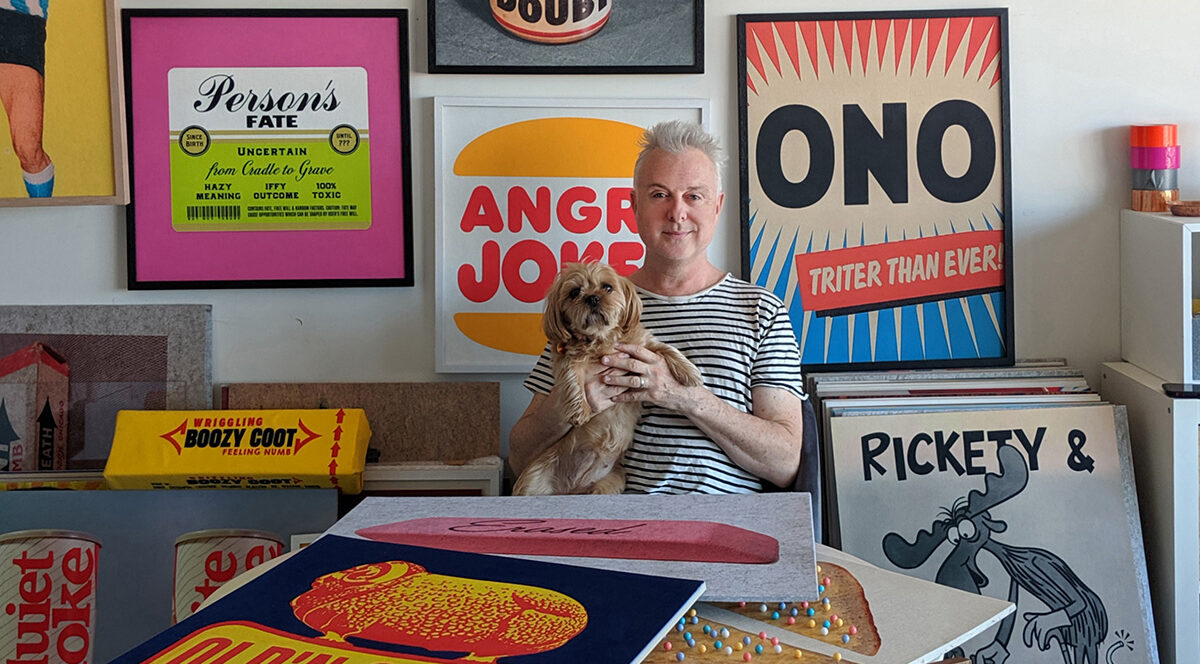 Portrait of artist David Art Wales with his dog Mr. Puppy among a selection of his acoustic felt prints