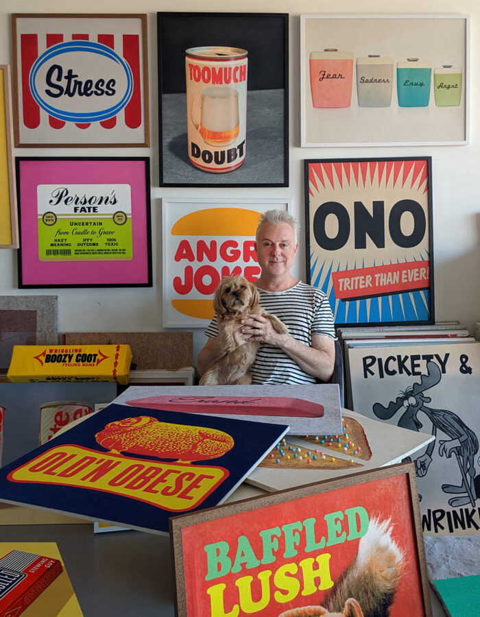 Portrait of artist David Art Wales with his dog Mr. Puppy among a selection of his acoustic felt prints